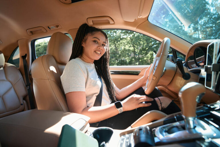 A female teen driver sits behind the steering wheel