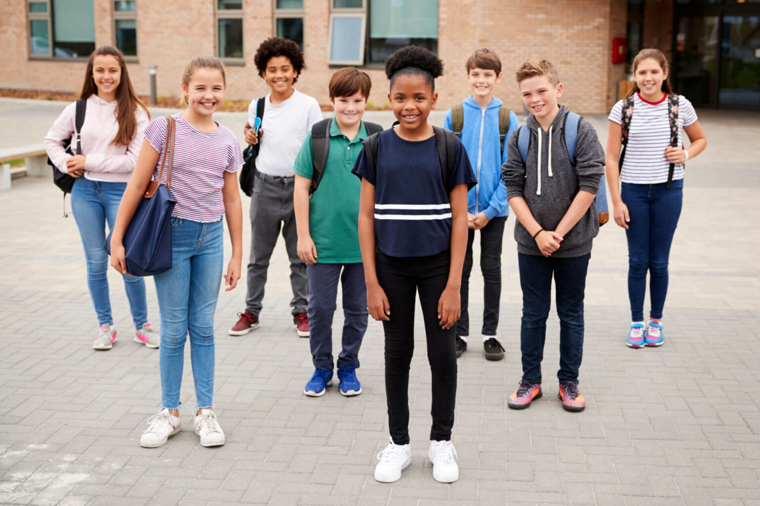 A group of students standing in front of their school