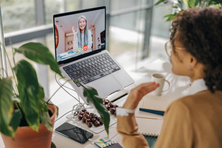 A woman uses a laptop for a video conference